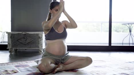 Angenehme-Schwangere-Frau,-Die-Zu-Hause-Yoga-Praktiziert